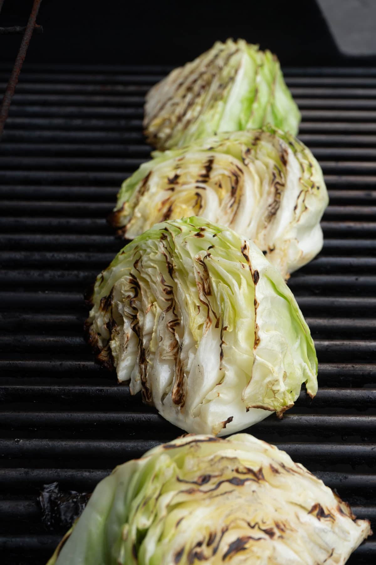 Grilled cabbage wedges on a barbecue.