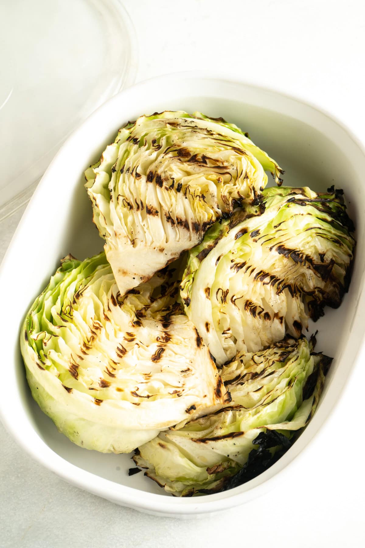 Grilled cabbage wedges in a dish.