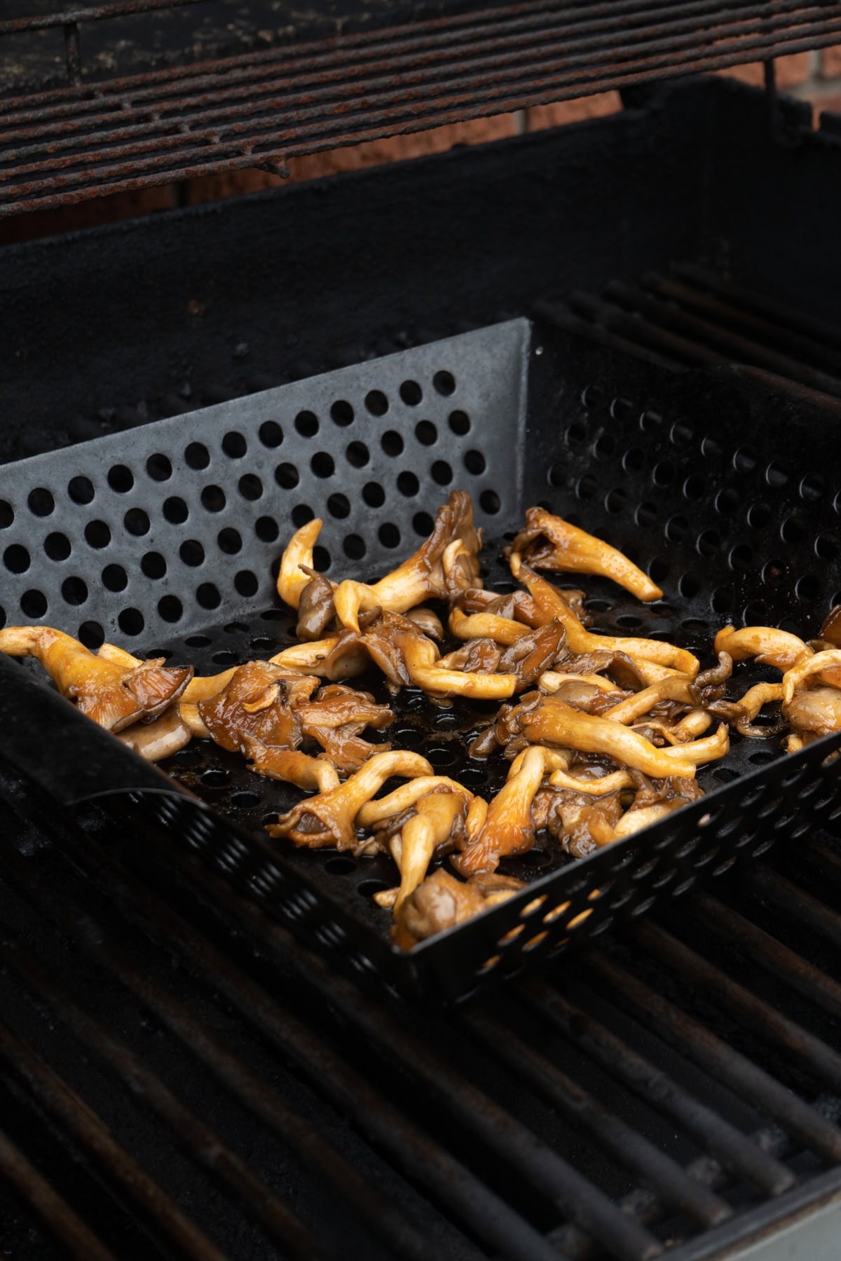 Oyster mushrooms being grilled on a barbecue.