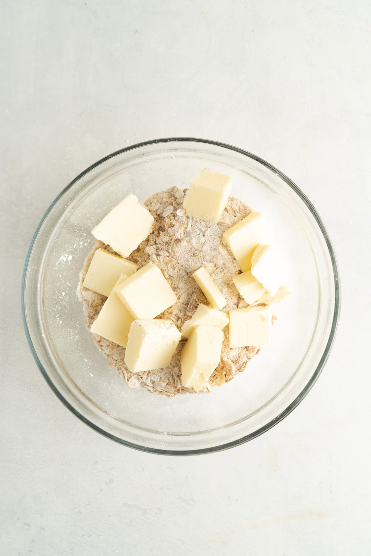A bowl of butter and an oat mixture to make a crumble topping.