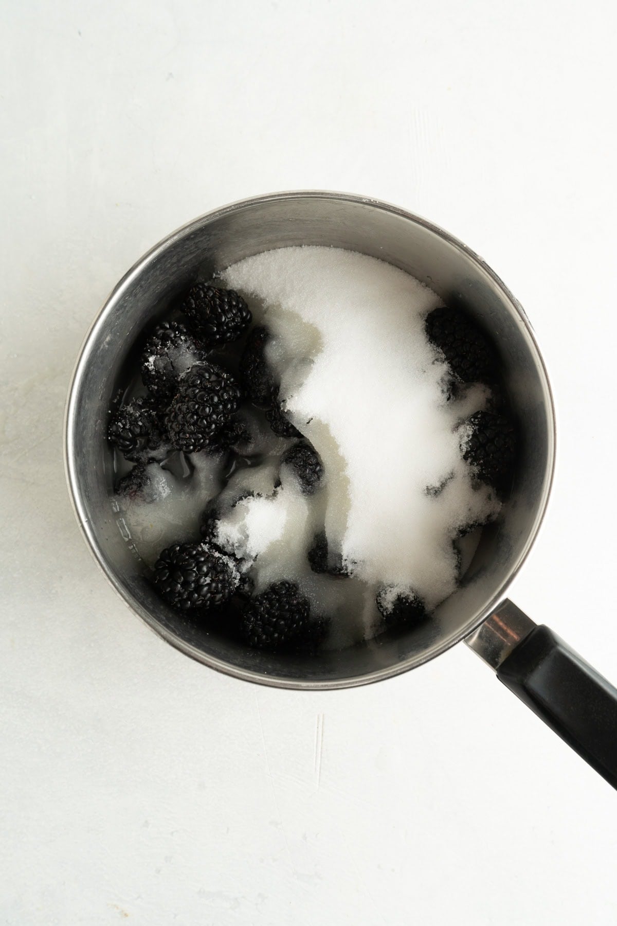 A pot of blackberries, sugar and lemon juice for a blackberry jam recipe.
