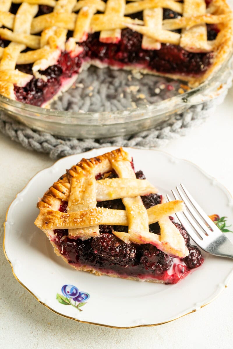 Homemade blackberry pie slice on a plate with a fork.