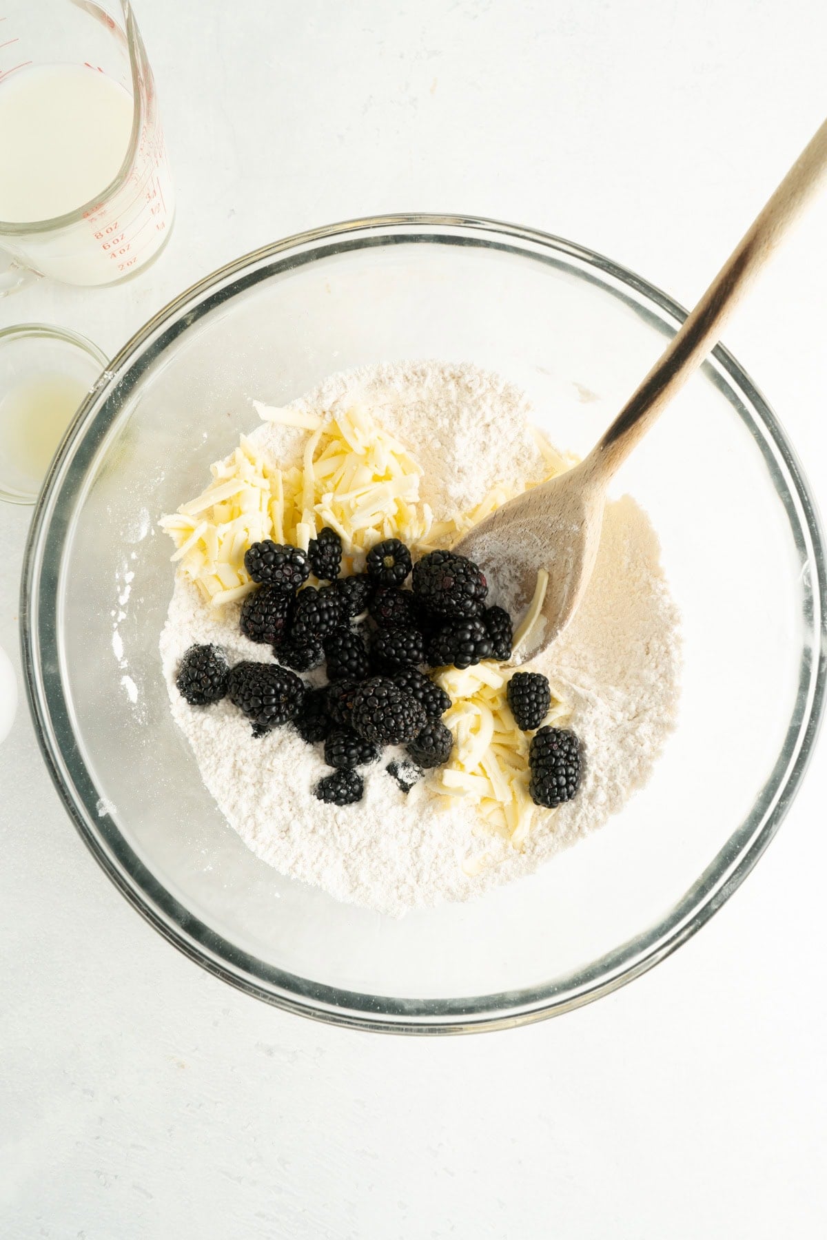 Dry ingredients for a recipe for blackberry scones in a bowl with a spoon.