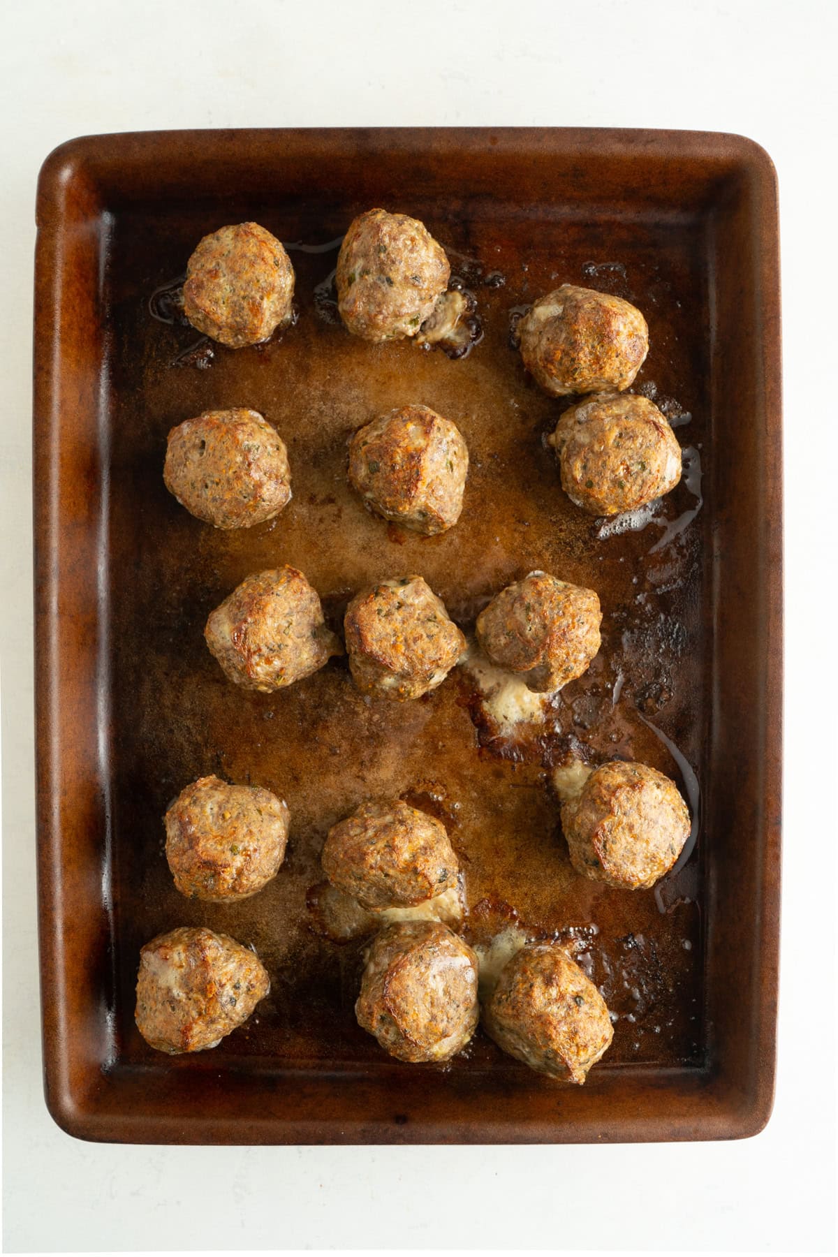 Easy Italian meatballs being baked on a baking sheet.
