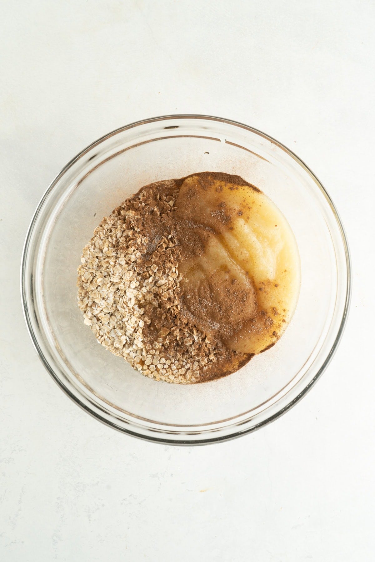 Ingredients for applesauce oatmeal cookies in a bowl.