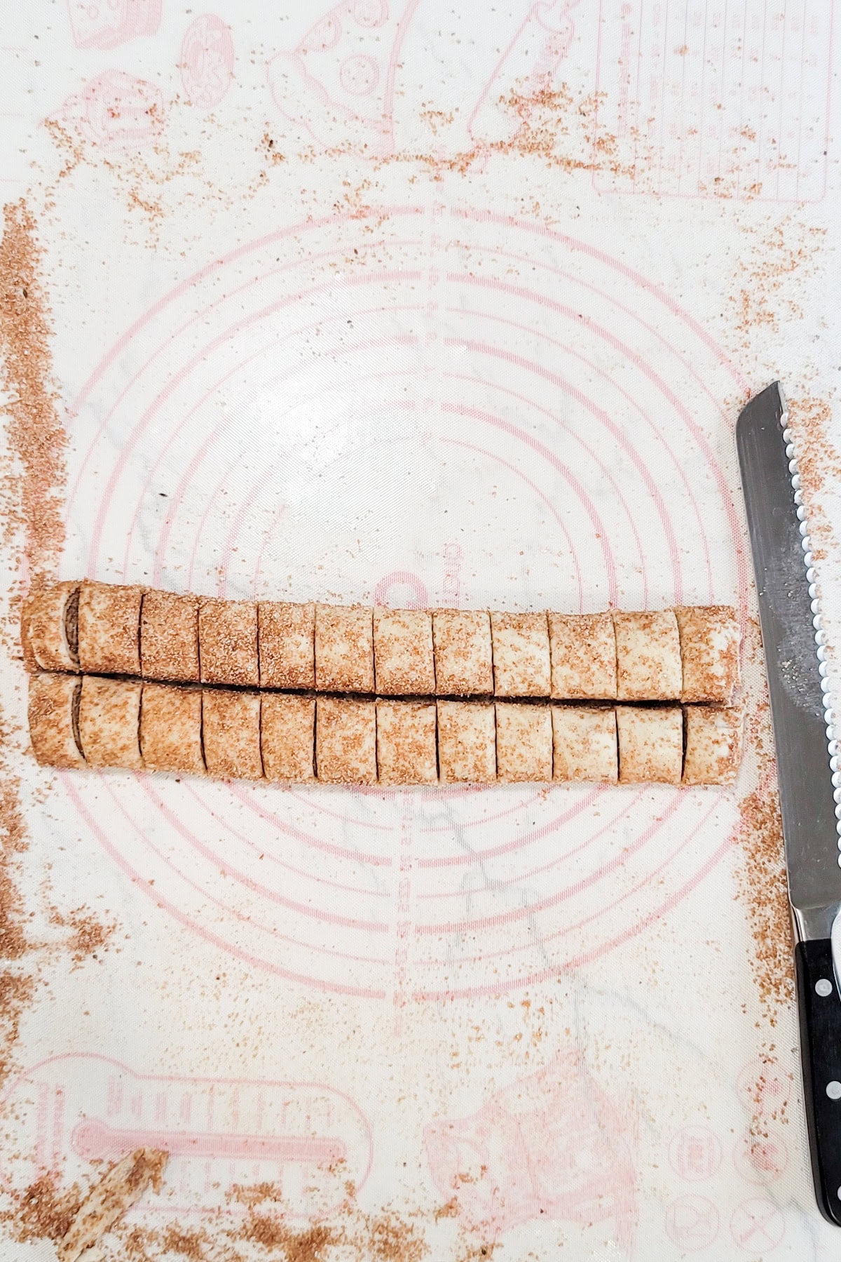 Palmiers being cut into slices before baking.