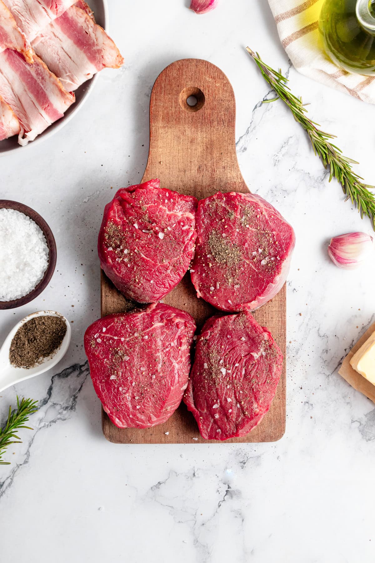 Seasoned Filet Mignon steaks on a cutting board.