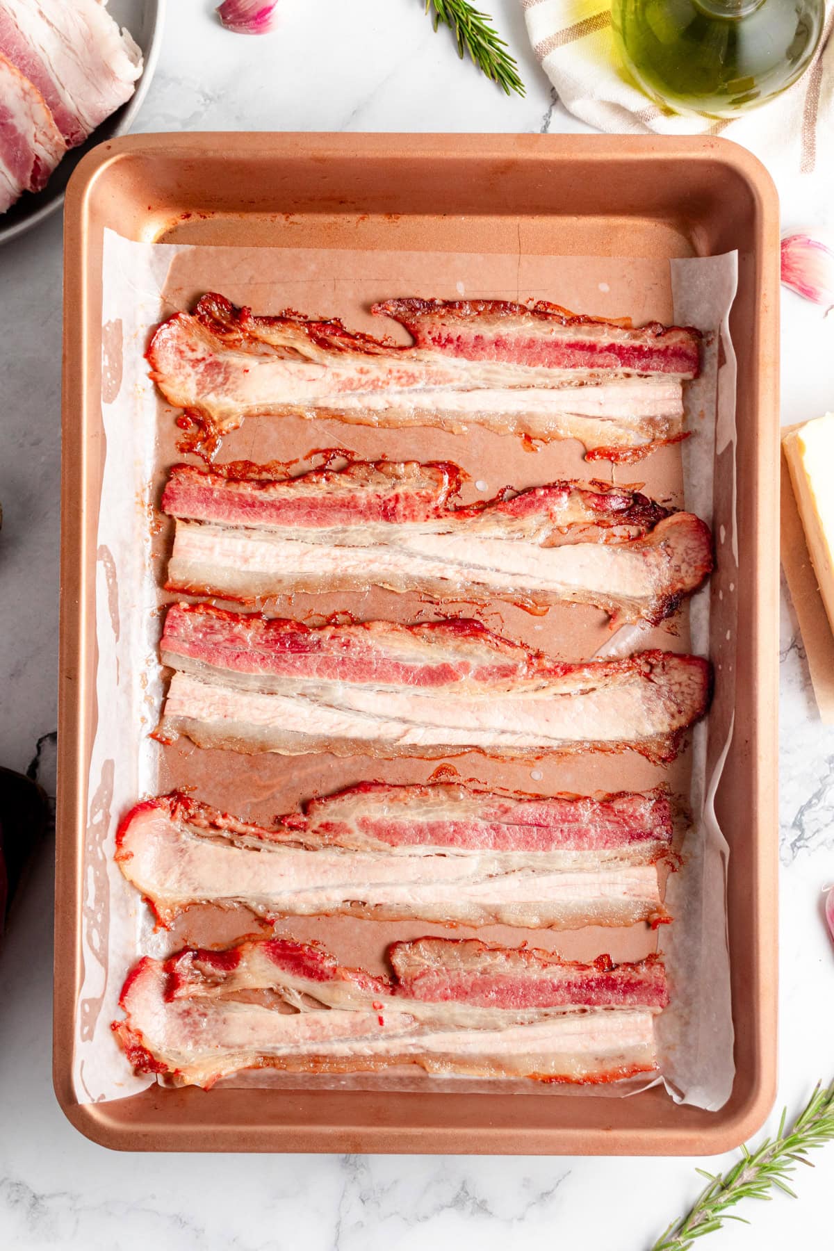 Cooked bacon on a baking sheet.