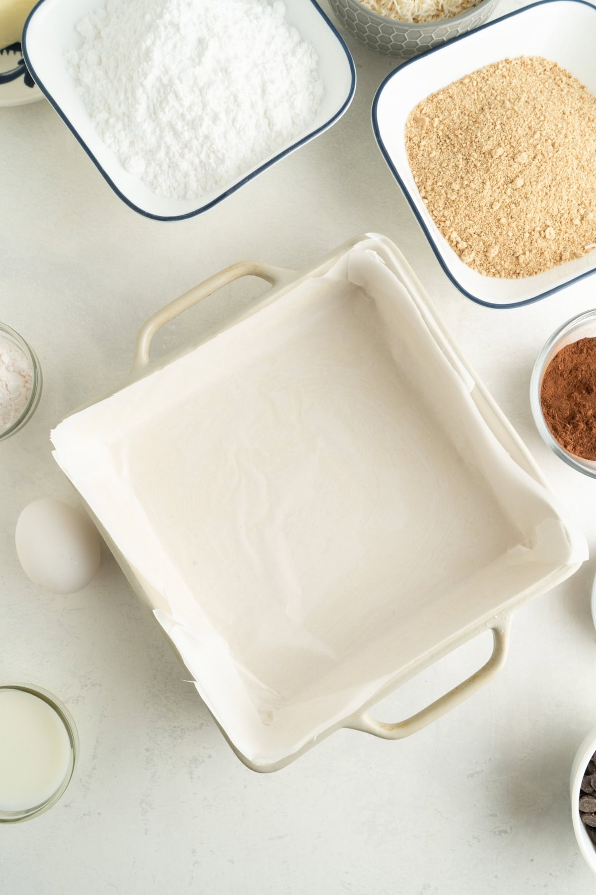 A square baking pan lined with parchment paper.