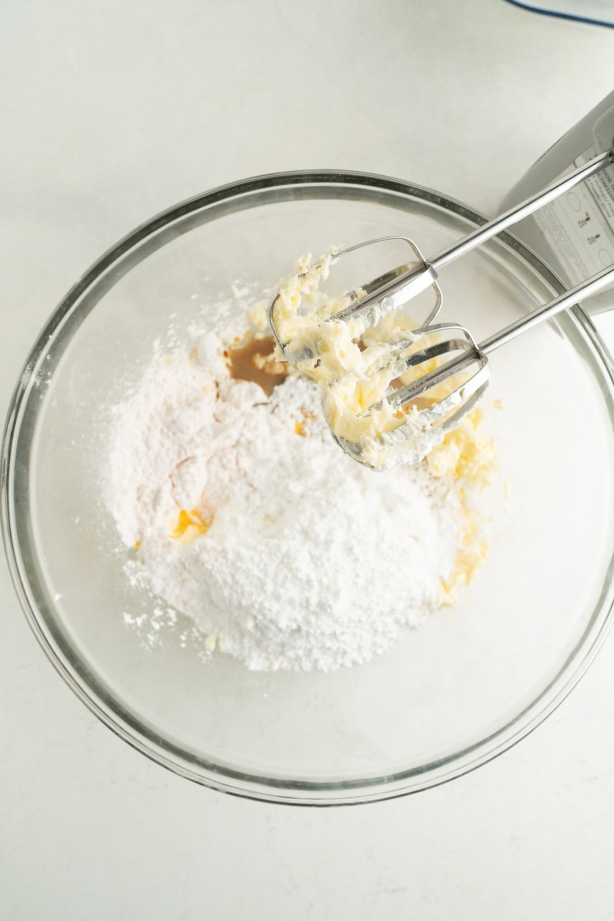 Ingredients for the custard filling for Nanaimo Bars being beaten with a mixer.
