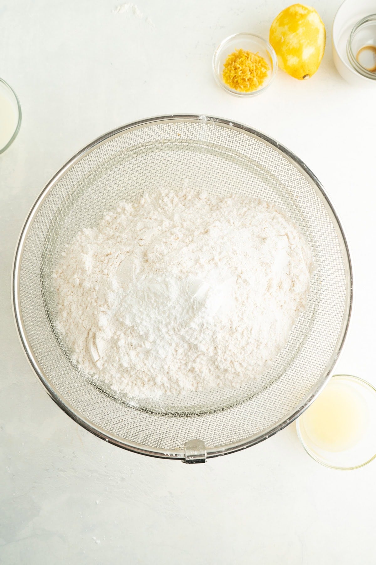 Flour in a sieve over a bowl.