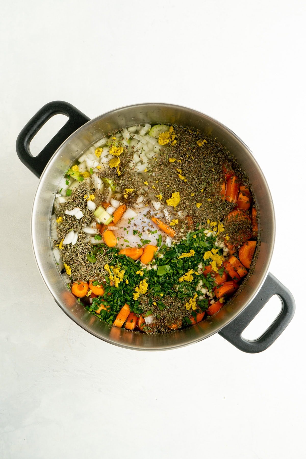 A large pot filled with ingredients for a homemade chicken soup recipe.