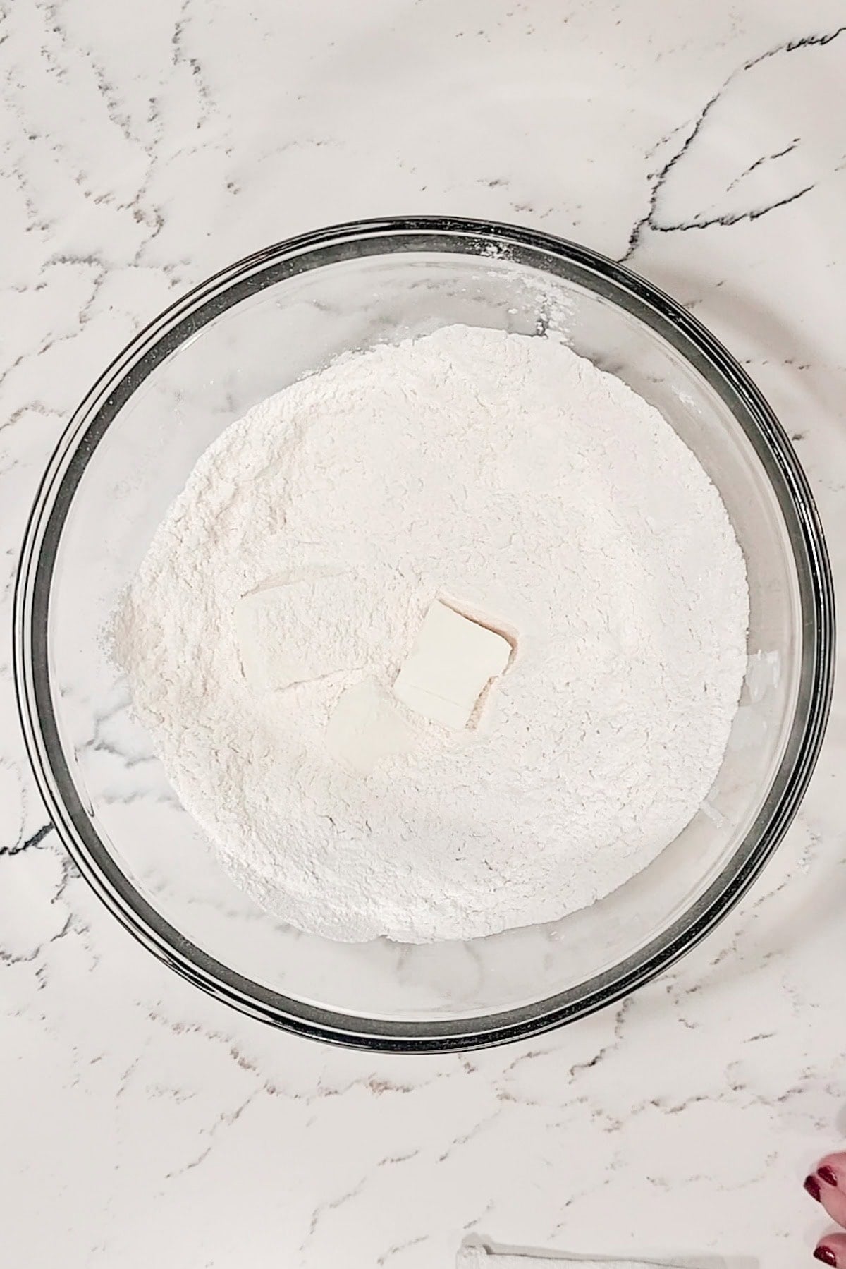 Vegetable shortening added to a bowl of flour.