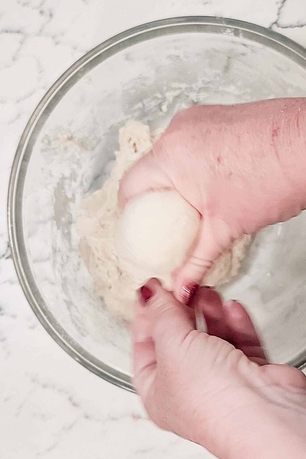 Forming dough into a round ball with hands.