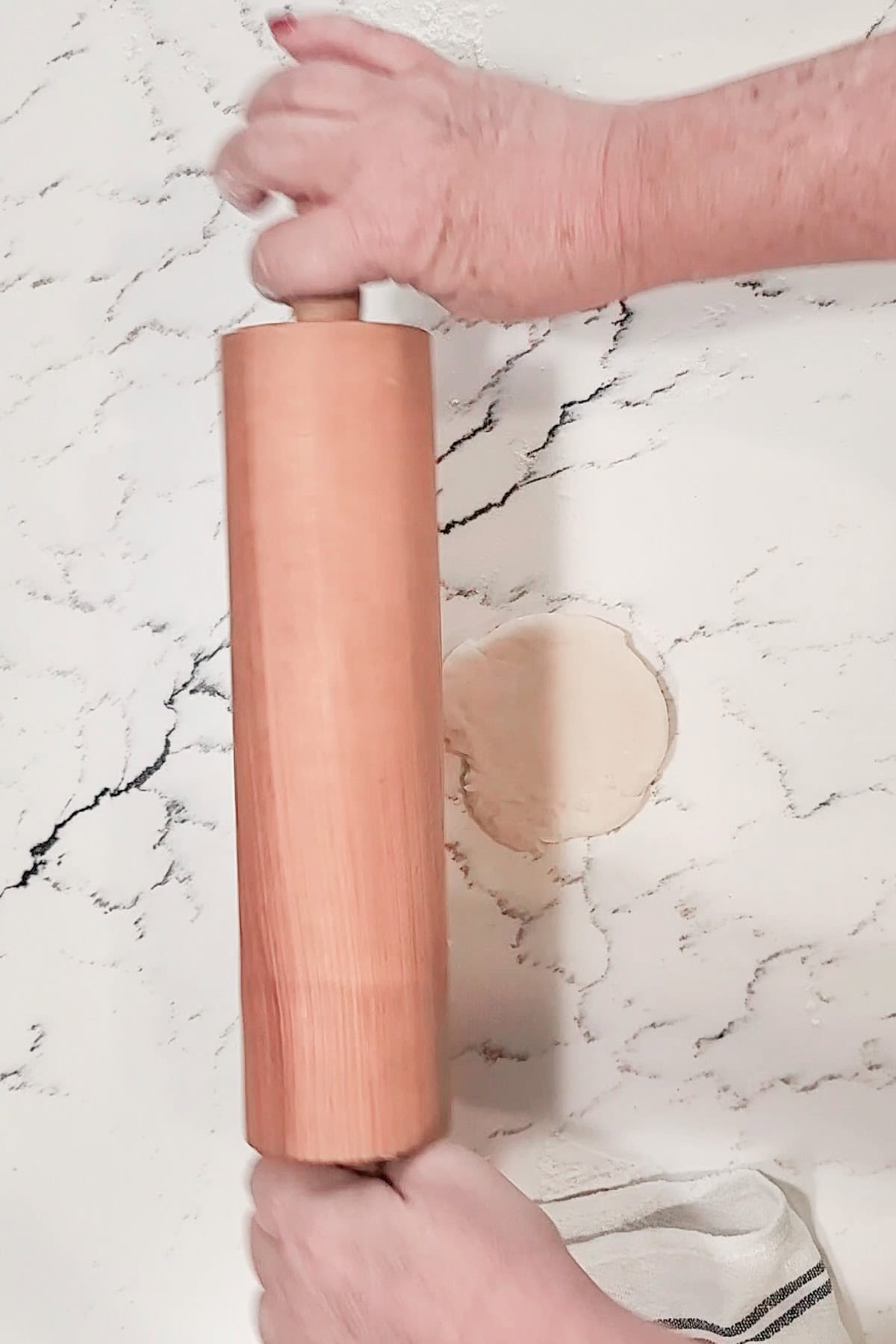 Roll ball of johnny cake dough into a round flat disk with a rolling pin.