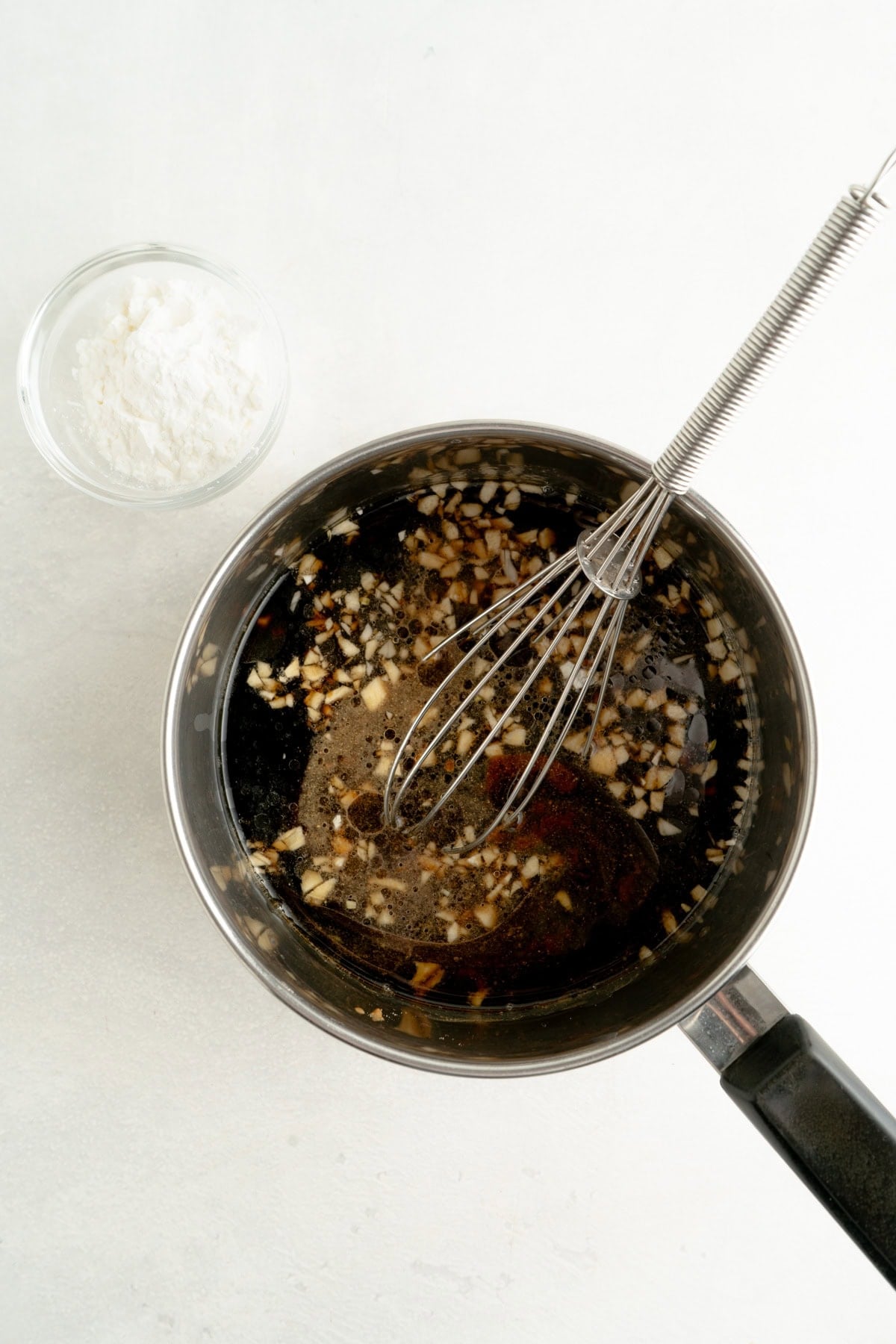 A teriyaki sauce recipe being whisked in a pot.