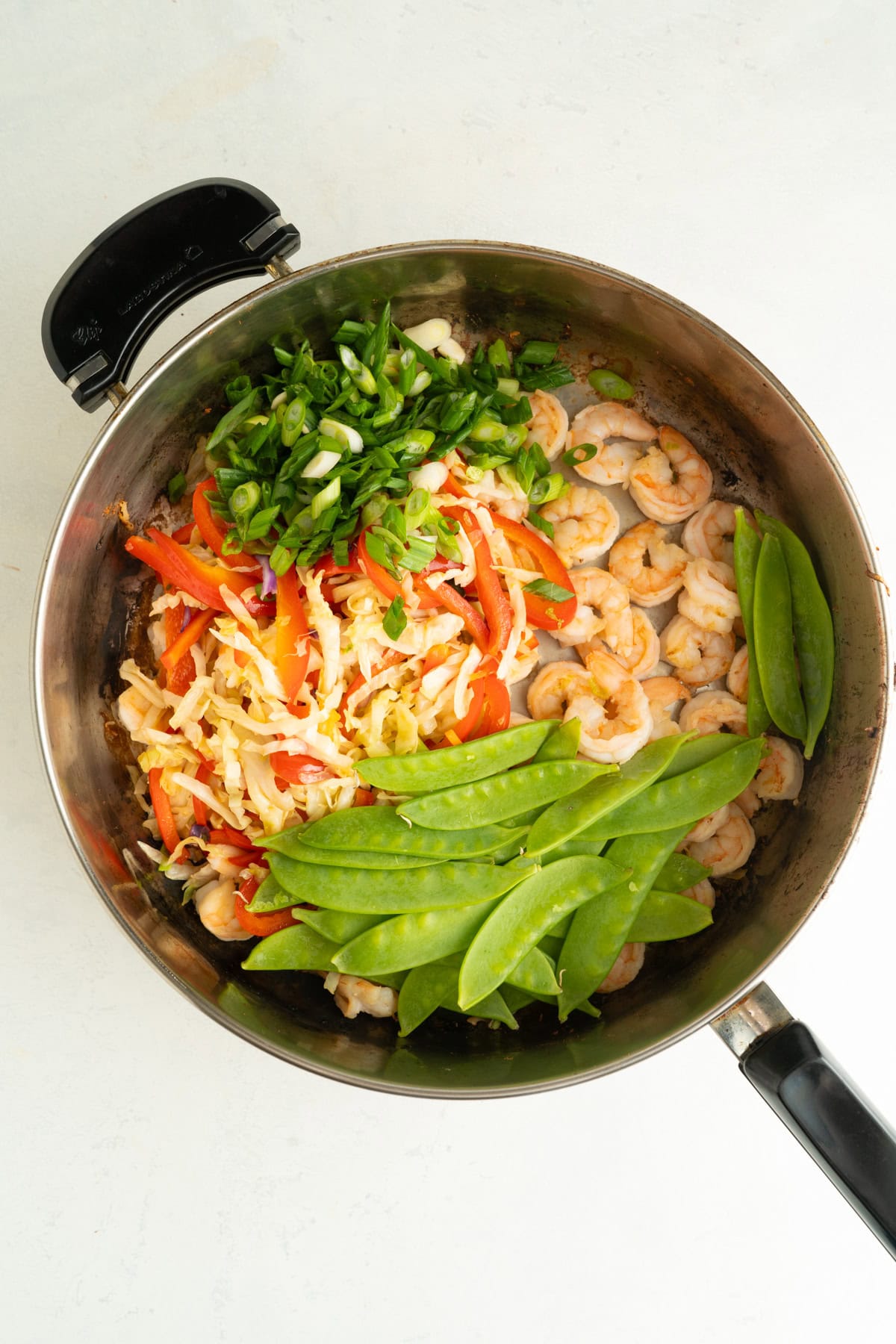Snow peas and green onions added to a shrimp stir fry