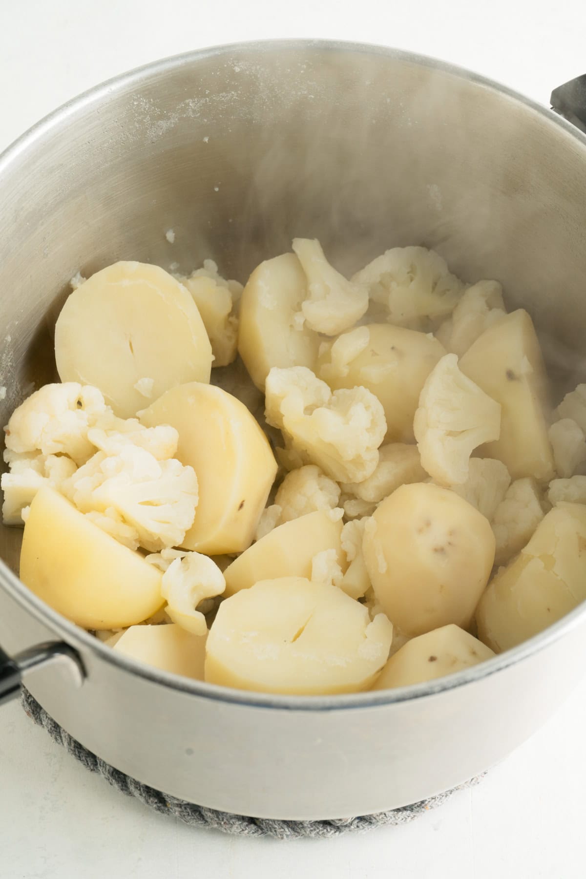 A pot of boiled potatoes and cauliflower.