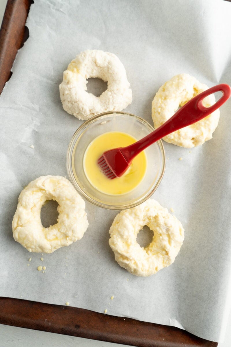Bagels being egg washed.