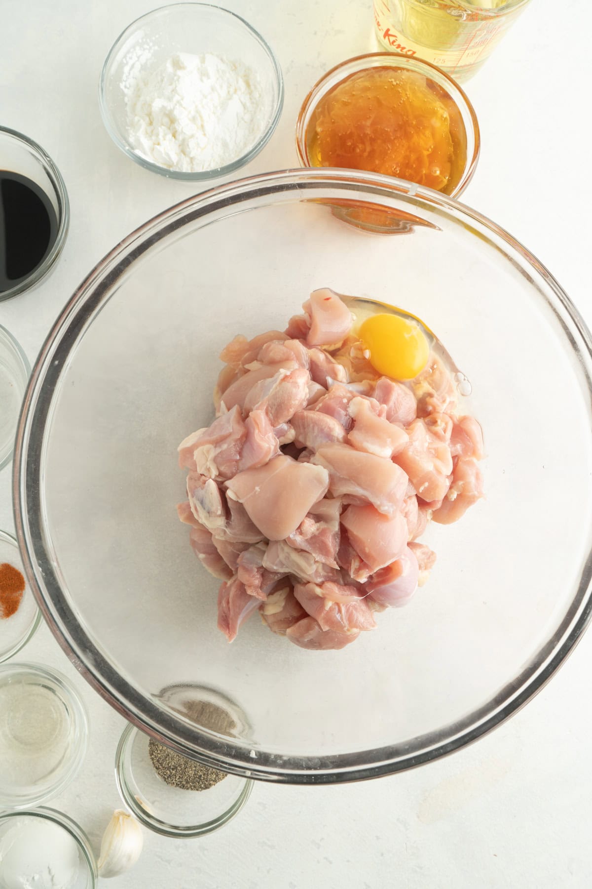 A bowl of cut up chicken with an egg inside.