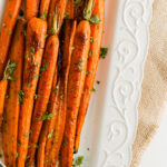 A close up of a platter or maple roasted carrots.