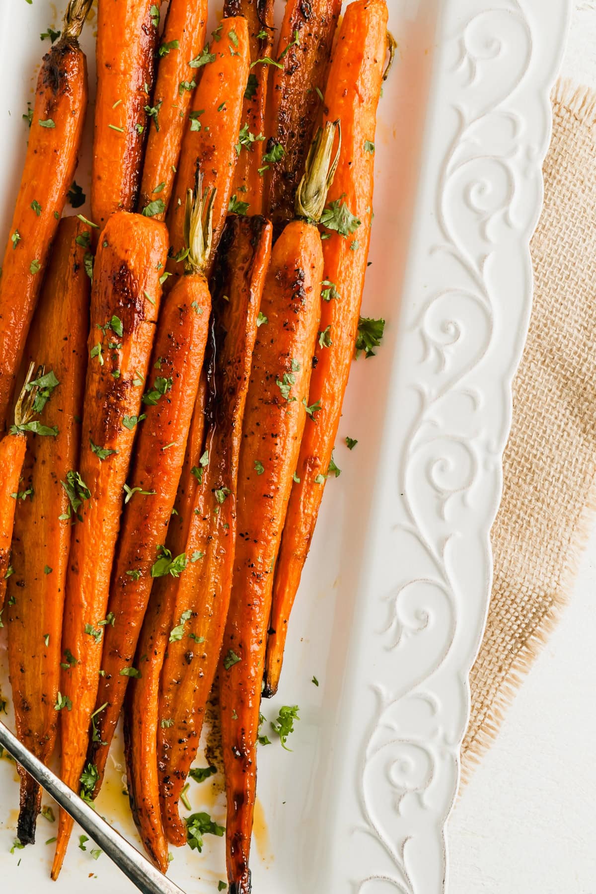 A close up of a platter or maple roasted carrots.