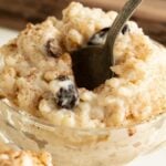 Pinterest pin showing a close up of a cup of rice pudding with a spoon.