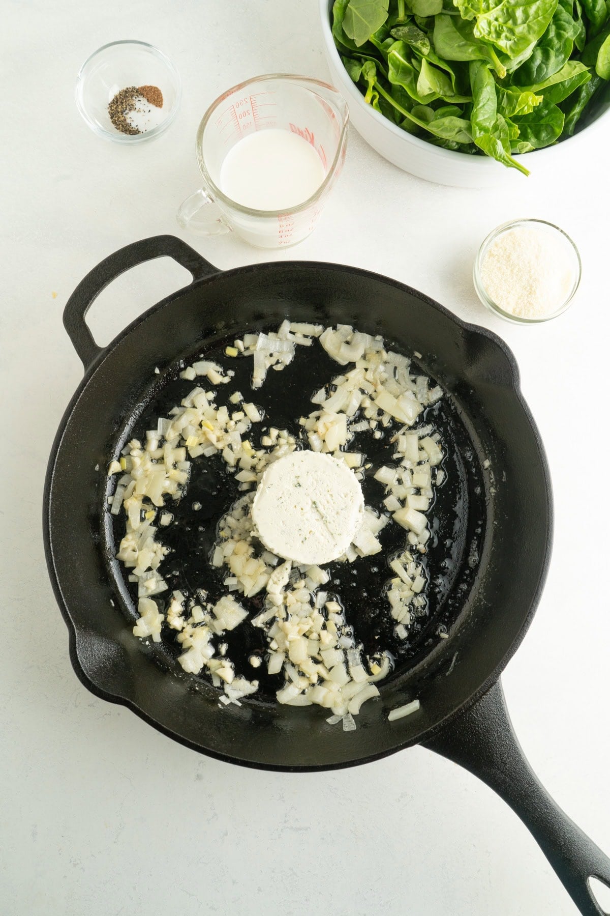 Onions and boursin in a cast iron pan.