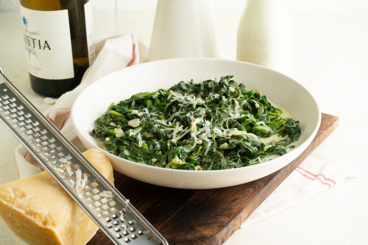 A bowl of creamed spinach on a table.