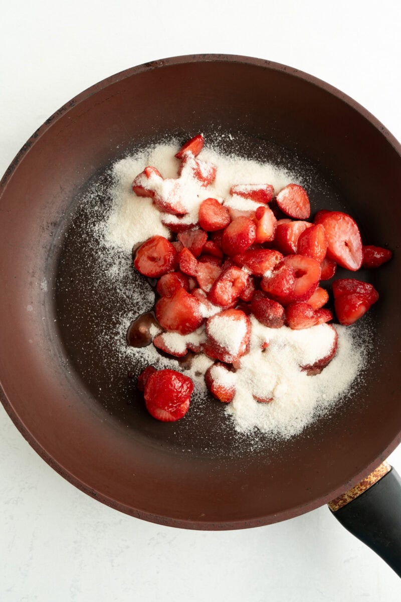 A pan of strawberries and sweetener.