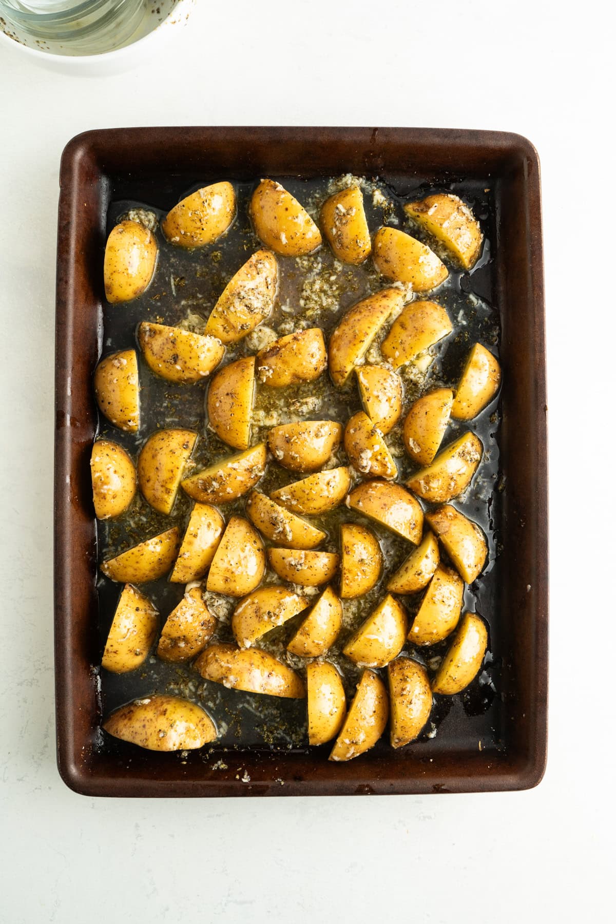 Greek marinated potatoes on a baking sheet.
