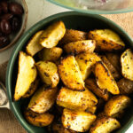 A bowl of baked lemon Greek Potatoes.