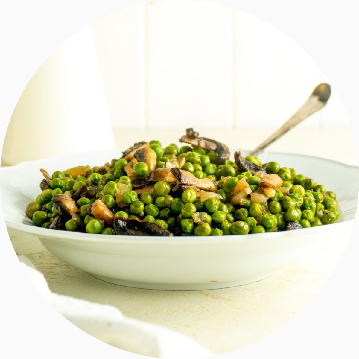 A bowl of peas in mushrooms in a circle frame.