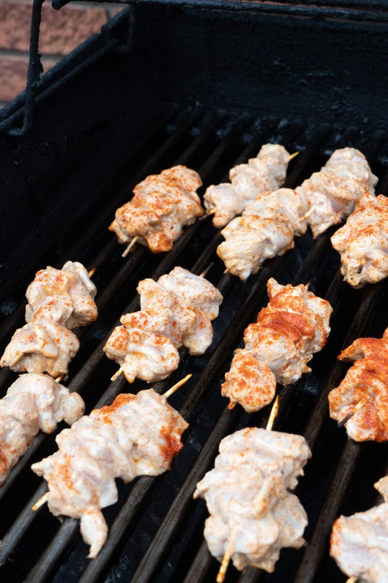 chicken skewers on a grill.