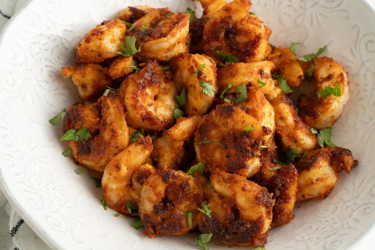 A bowl of seasoned pan fried shrimp.