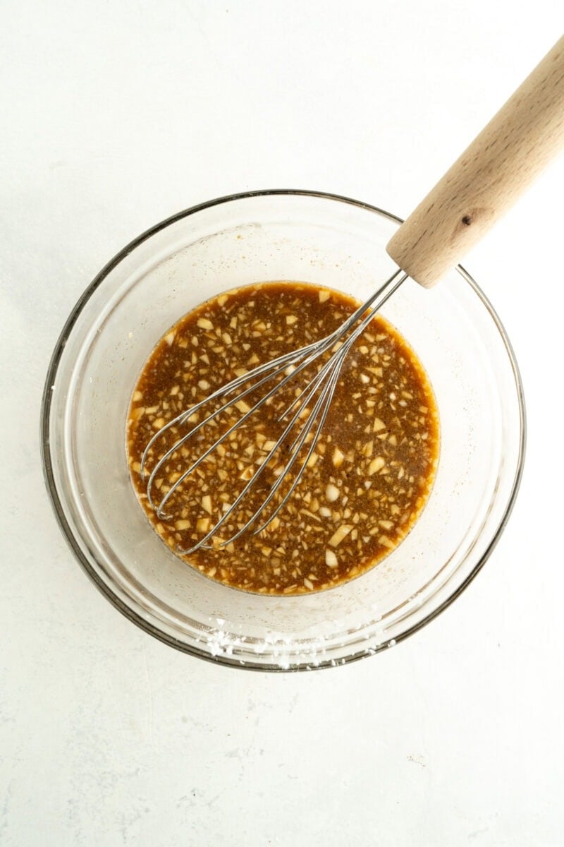 Teriyaki sauce being made in a bowl with a whisk.