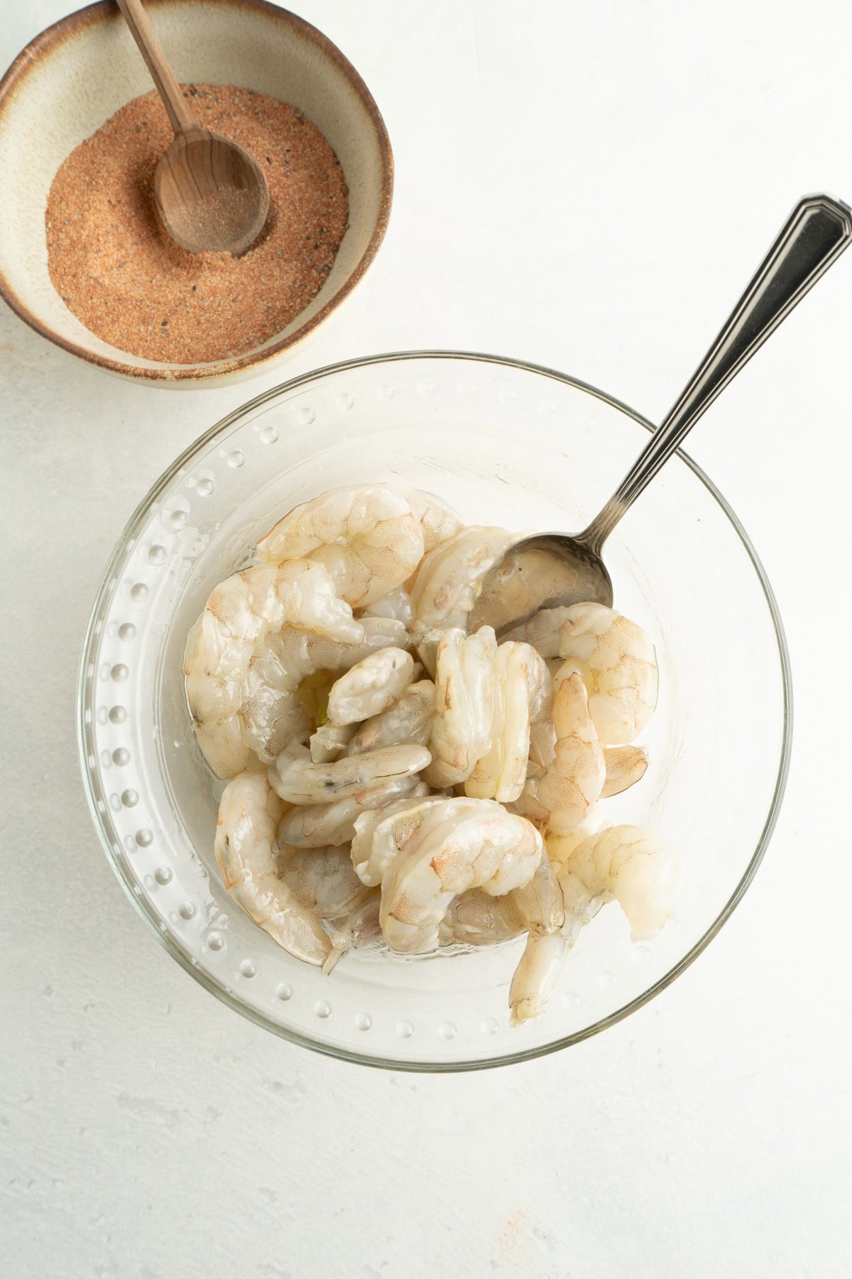 A bowl of peeled shrimp tossed in olive oil