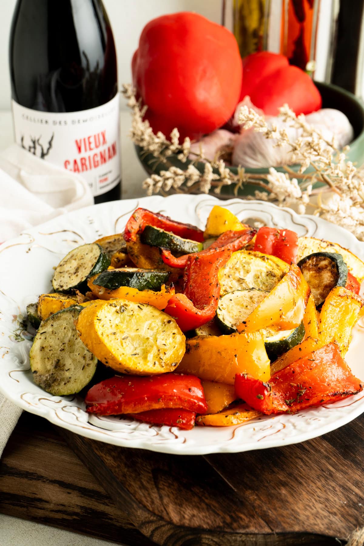 A bowl of roasted zucchini and peppers on a table.
