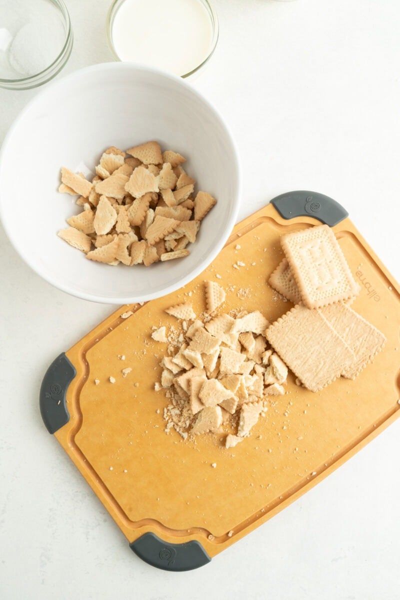 Breaking up vanilla wafers and adding to a bowl.