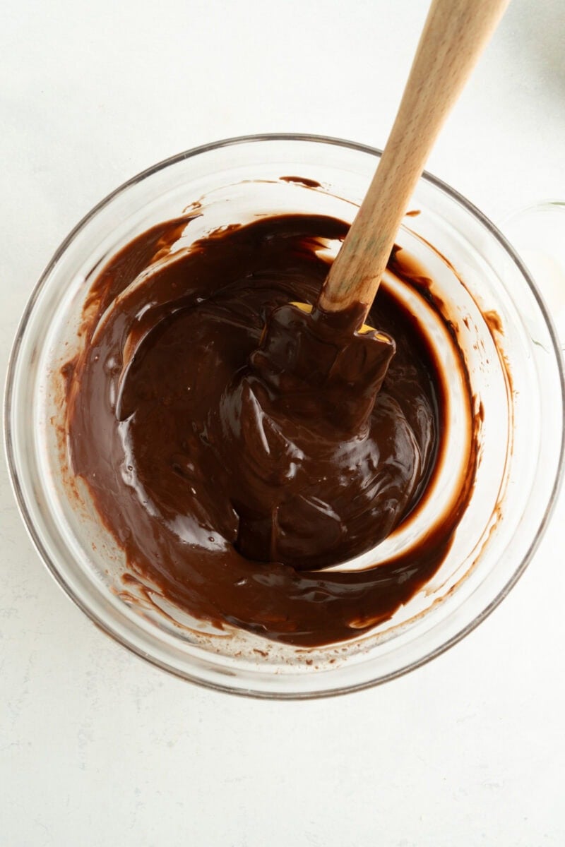 A bowl of melted chocolate with a spoon.