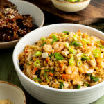 A bowl of shrimp and chicken fried rice on a table.