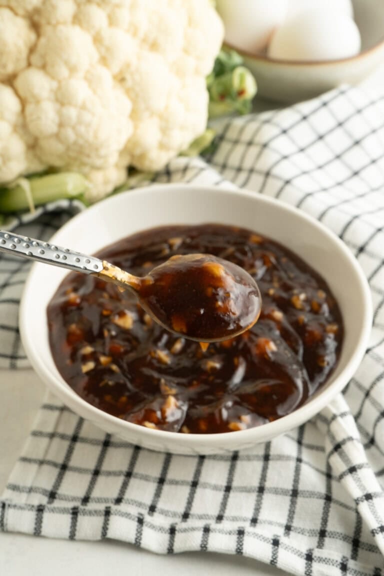 A bowl of Asian BBQ sauce with a spoonful lifted.