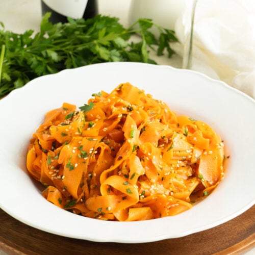 A bowl of carrot ribbon salad on a dinner table.