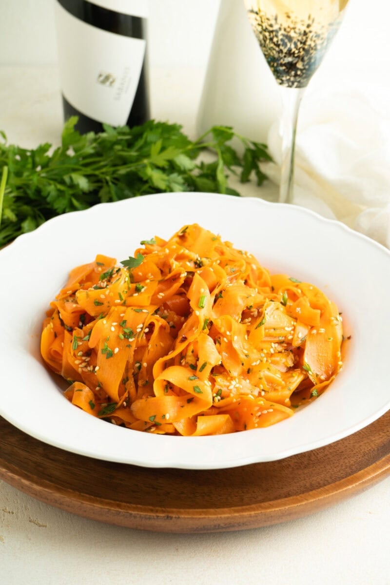 A bowl of carrot ribbon salad on a dinner table.