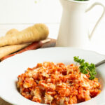A bowl of mashed carrots and parsnips on a dinner table.