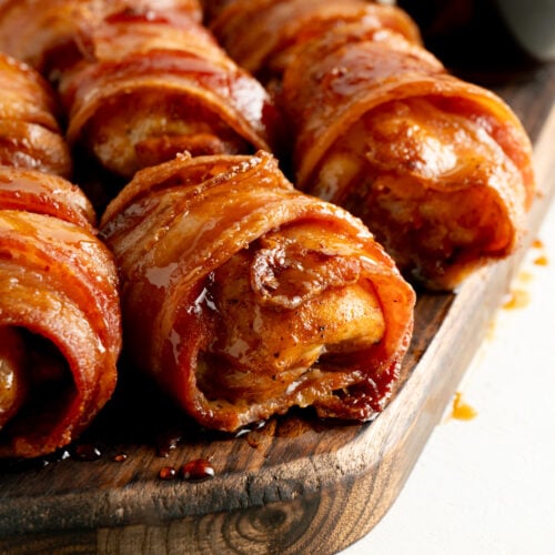 Bacon Wrapped Chicken Thighs on a wood cutting board.