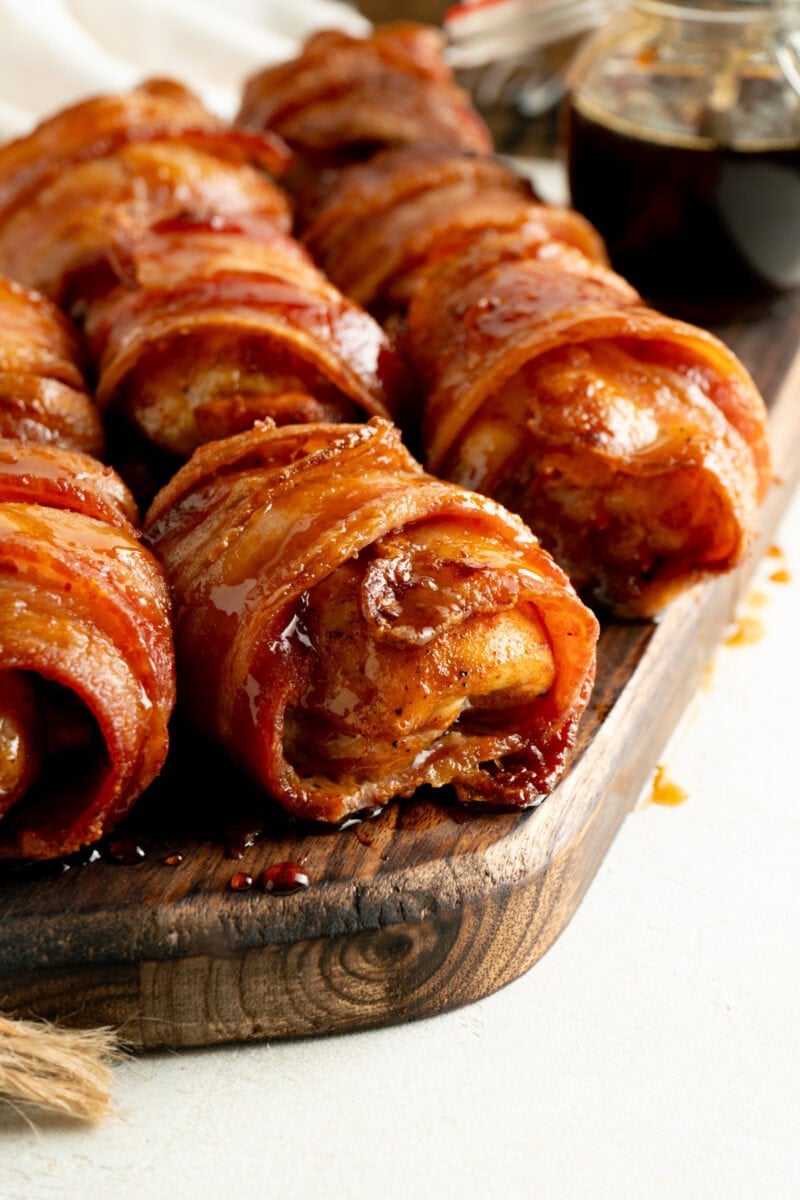 Bacon Wrapped Chicken Thighs on a wood cutting board.