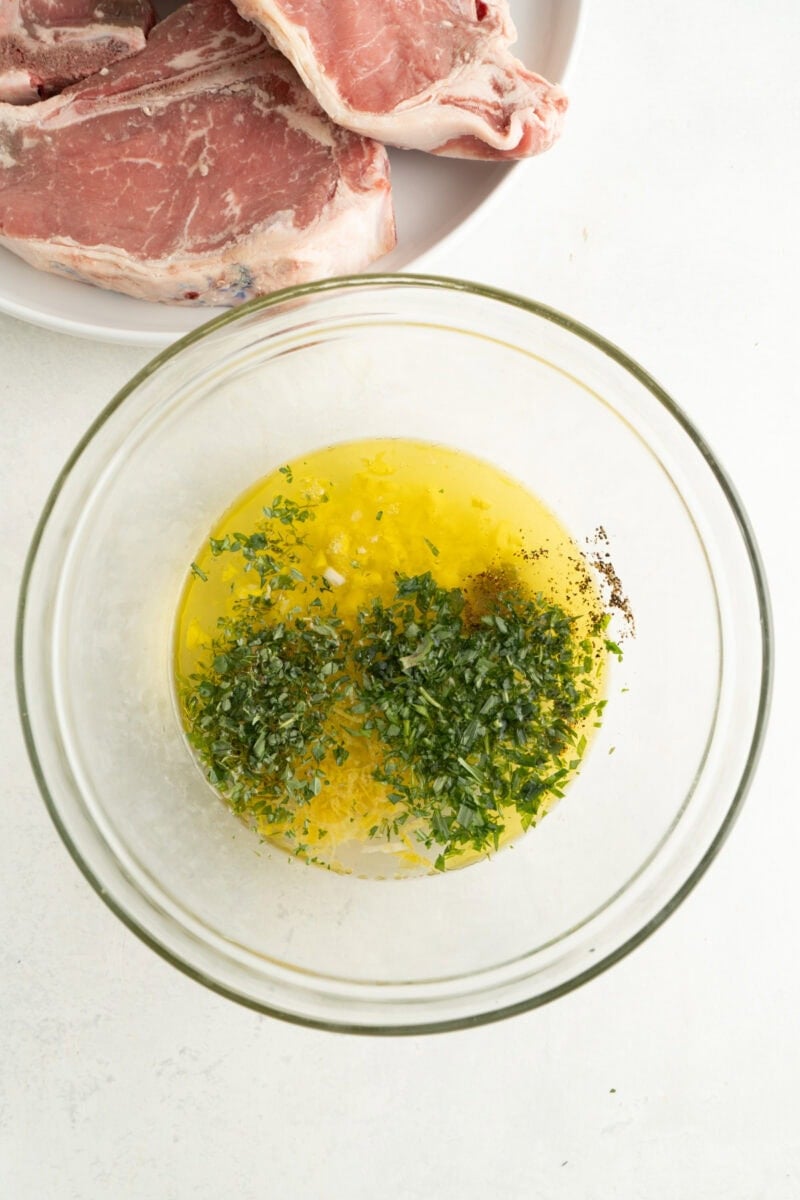 Herb and lemon marinade being prepared in a bowl.