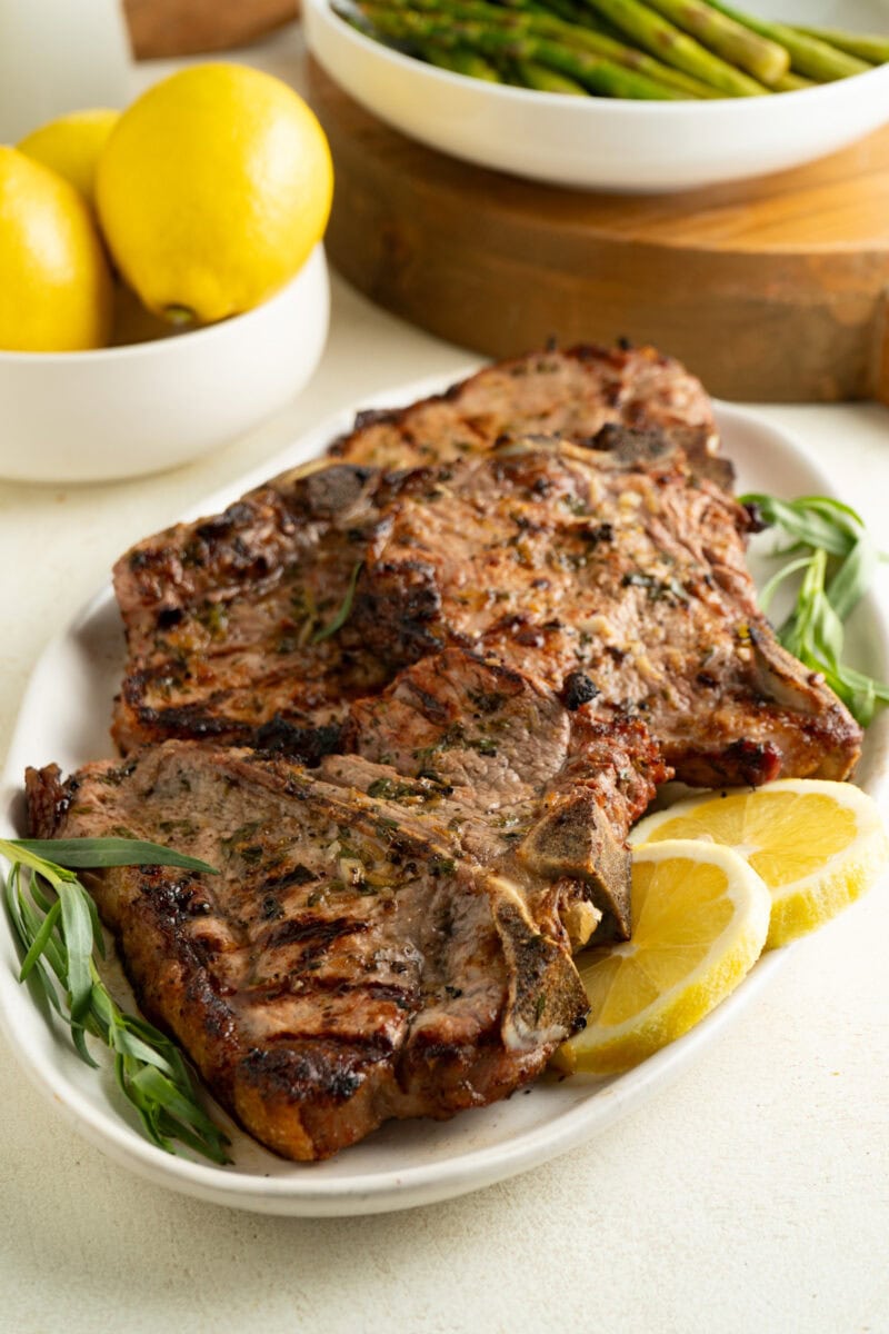 A platter of grilled veal chops with lemon and tarragon.