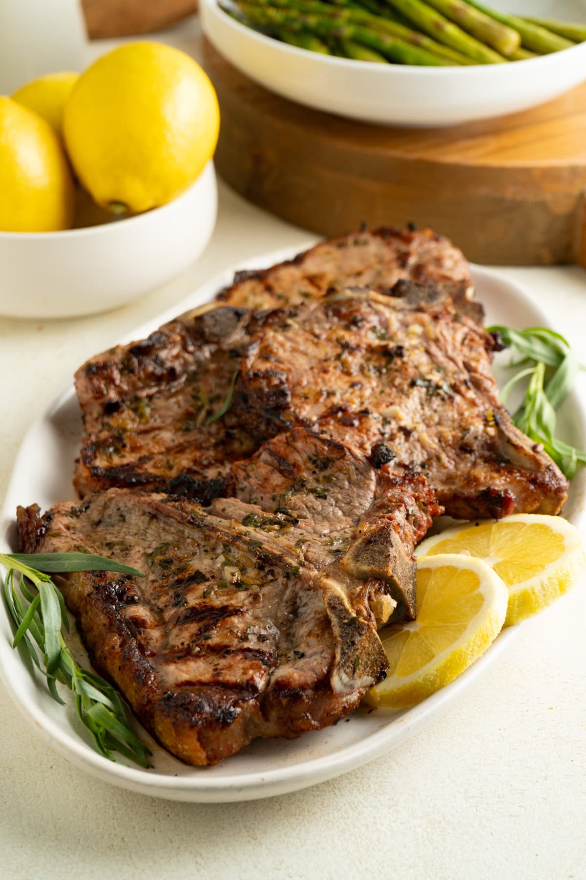 A platter of grilled veal chops with lemon and tarragon.